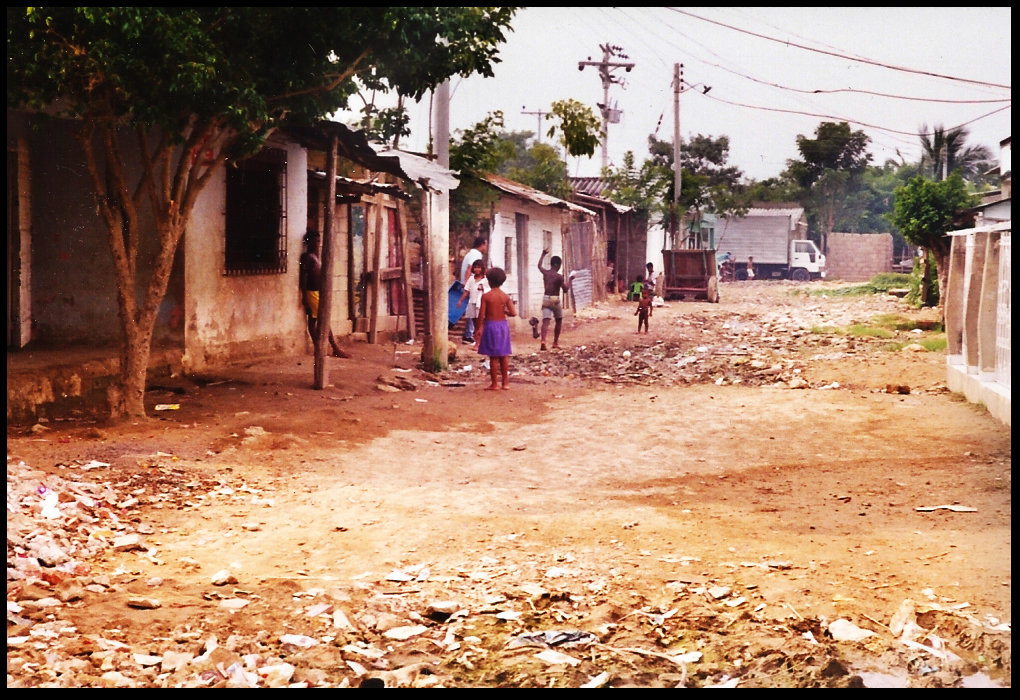 several
              cinderblock huts along a Poz&oacute;n littered street with
              barely clad children playing
