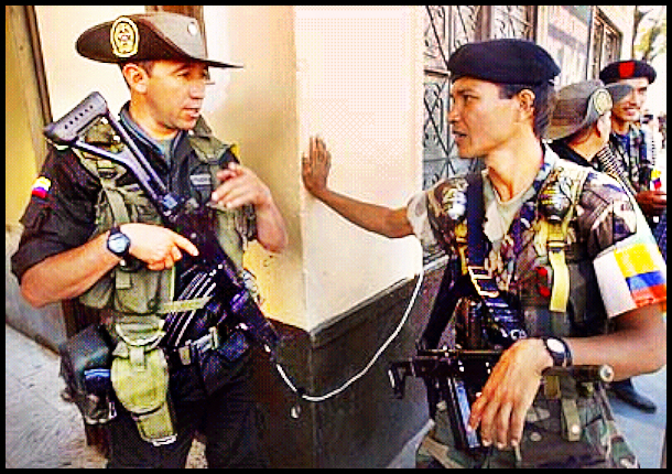 both fully equipped and then some,
              army-uniformed soldier in brown 3-corner hat talks with
              FARC rebel in navy beret