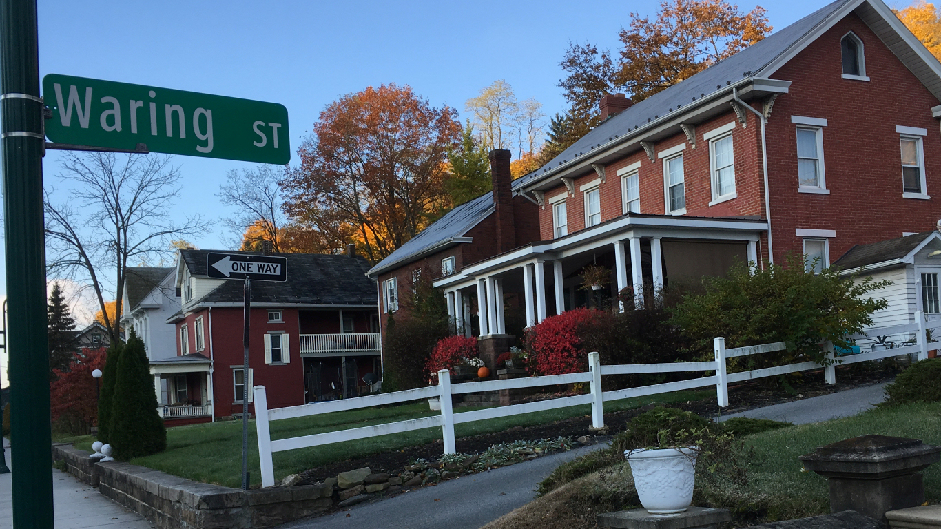 big red brick houses in a row on a hill cut
                by an alley whose street sign reads 'Waring St'