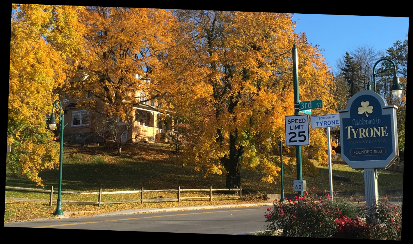 big house on hill in front of which are signs saying
              'Welcome to Tyrone' and 'Borough of Tyrone'